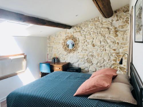 une chambre avec un lit et un mur en pierre dans l'établissement Joli duplex avec terrasse, à Marseille