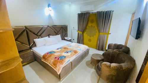ein Schlafzimmer mit einem Bett und Stühlen in der Unterkunft One Click Guesthouse in Islamabad