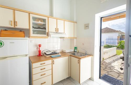 a kitchen with a sink and a refrigerator at Tropical Beach A1 in Kalamaki