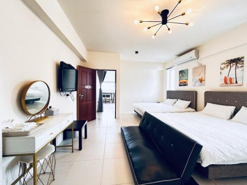 a bedroom with two beds and a desk and a mirror at 海景 綠島極光輕旅 代訂船票 租摩托車浮潛 藍洞跳水 體驗潛水 in Green Island