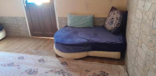 ein kleines Bett in einem Zimmer mit einer Wand in der Unterkunft Mimi cheriti in Bordj Lutaud