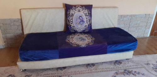 ein Bett mit einer blau-weißen Decke drauf in der Unterkunft Mimi cheriti in Bordj Lutaud