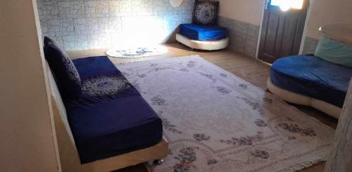 a bedroom with two beds and a rug on the floor at Mimi cheriti in Bordj Lutaud