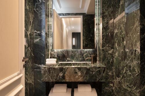 une salle de bain avec un lavabo et un miroir dans l'établissement TheLander - Serviced Apartments in Champs Elysées, à Paris