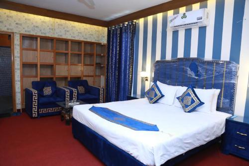 a bedroom with a bed with blue and white stripes at Hotel palm east lahore in Lahore