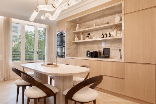 une cuisine avec une table et des chaises dans une pièce dans l'établissement TheLander - Serviced Apartments in Champs Elysées, à Paris