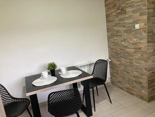 a dining room table with chairs and a table and a wall at Zaciszny zakątek pod Różą in Skawinki