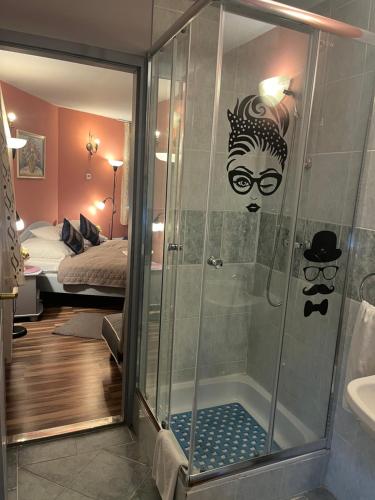 a bathroom with a shower with a man with glasses at HOTEL Kuruc Panzio TARPA Kossuth utca 25E 