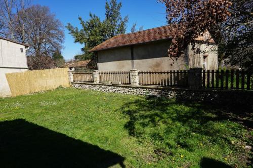 a fence in front of a house with a yard at Maison de village périgourdin in Bouniagues