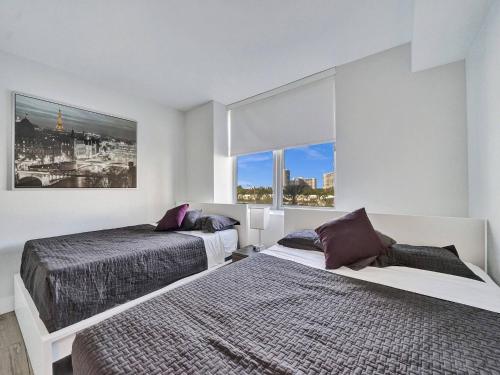 Un dormitorio con dos camas y una gran ventana. en Luxury Waterfront Suite, en Hallandale Beach