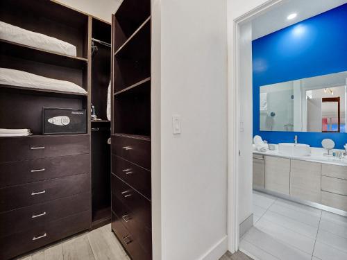 Un baño con lavabo y un espejo grande. en Top Floor Luxury Penthouse with Private Roof Deck, en Hallandale Beach