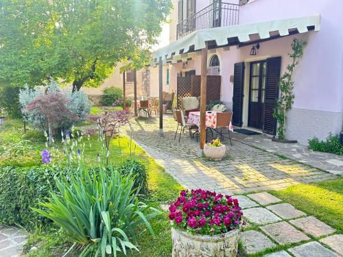 a garden with a table and chairs and flowers at La Casa Di Campagna Sul Garda in Puegnano del Garda
