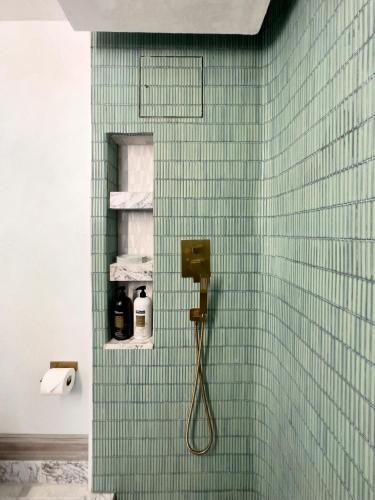 a green tiled bathroom with a shower with a phone at Shadowcrest in Fleischmanns