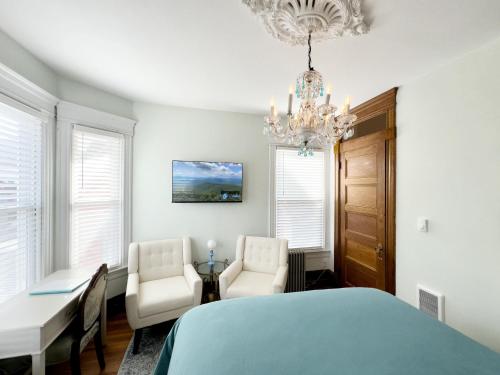 a bedroom with a bed and two chairs and a table at Shadowcrest in Fleischmanns