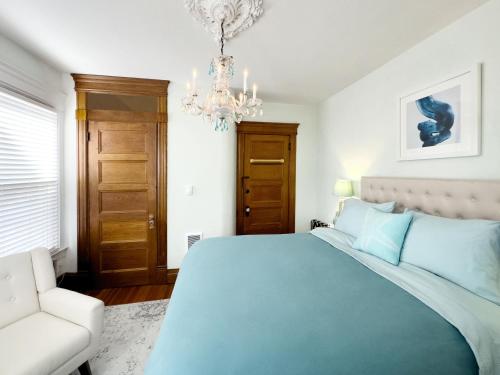 a bedroom with a blue bed and a chandelier at Shadowcrest in Fleischmanns
