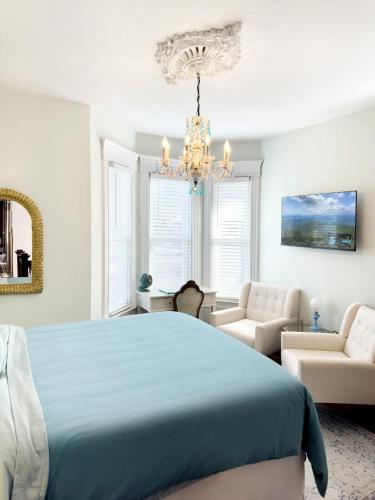 a bedroom with a blue bed and a chandelier at Shadowcrest in Fleischmanns