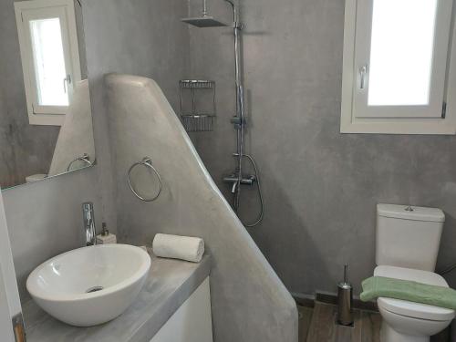 a bathroom with a sink and a shower and a toilet at Anchorage Andros Villa in Andros