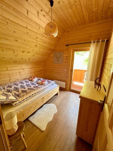 a bedroom with a bed in a wooden cabin at Sielska Chata Beskidy in Zawoja