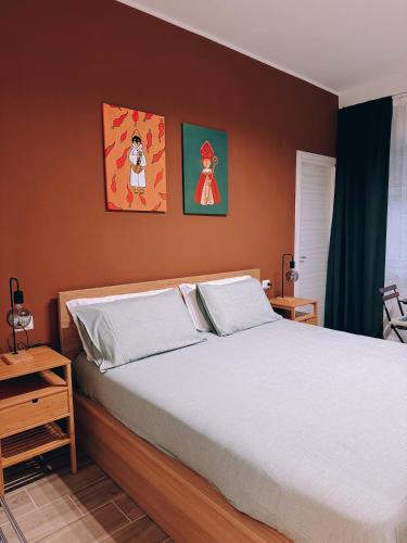 a bedroom with a bed and two paintings on the wall at EllePì Rooms in Naples