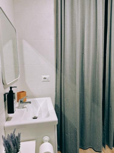 a bathroom with a sink and a shower curtain at EllePì Rooms in Naples