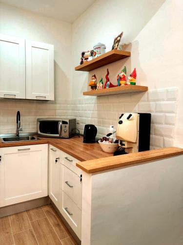 a kitchen with white cabinets and a counter top at EllePì Rooms in Naples