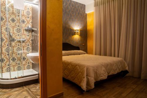 a bedroom with a bed and a bathroom with a sink at Hotel Il Guercino in Bologna