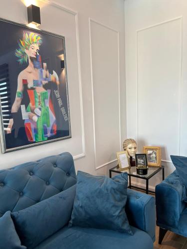 una sala de estar con un sofá azul y una pintura en Daphne Luxe Retreat -Sea View-King size bed-, en Supetar