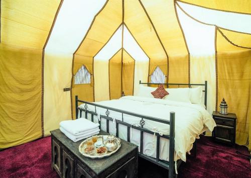 a bedroom with a bed in a tent at desert indigo luxury camp in Merzouga