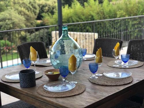 une table en bois avec un vase en verre au-dessus dans l'établissement Villa de Lila, à Arpaillargues-et-Aureillac
