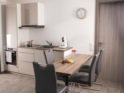 a kitchen with a table and chairs and a clock on the wall at Bantlehof in Niedereschach