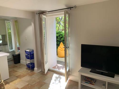 d'un salon avec une télévision et une porte coulissante en verre. dans l'établissement Lovely and calm, à Cannes