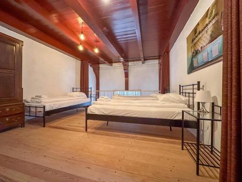 two beds in a large room with wooden floors at Weeshuis klein in Enkhuizen