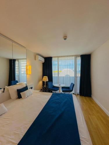 a bedroom with a large bed with a blue blanket on it at Seaside vip Hotel in Batumi