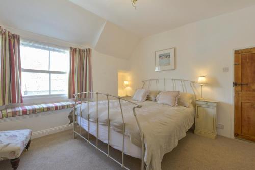 a bedroom with a bed and a window at April Cottage in Coverack