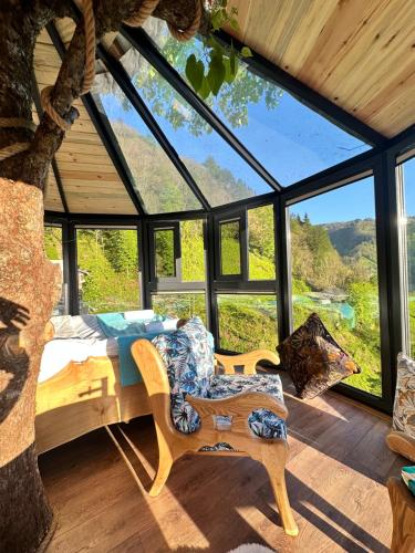 a bedroom in a tree house with a large window at Northland Bungalows in Çayırdüzü