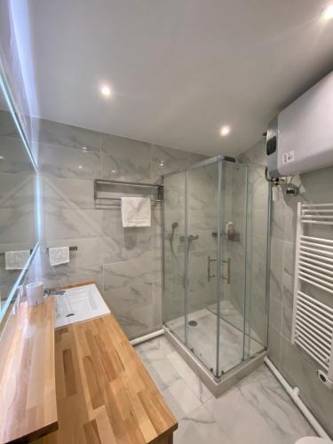 une douche avec une porte vitrée dans une salle de bain dans l'établissement Appartement neuf à louer, Paris Sacré Cœur, à Paris