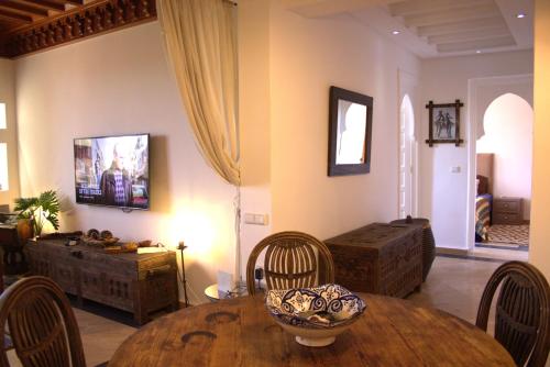 a living room with a wooden table and chairs at El Ghoul Apartments & flats - Résidence Dyar Alkheir in Marrakech