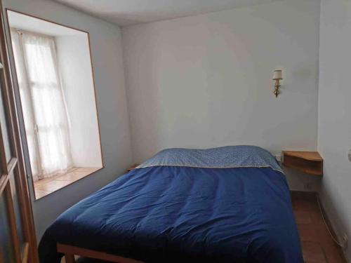 une chambre avec un lit bleu et une fenêtre dans l'établissement La Belle Marguerite, appartement privé dans maison, à Brochon