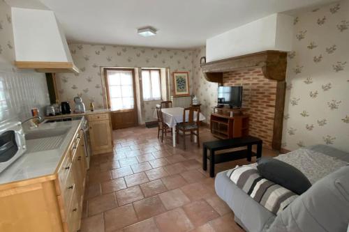 une cuisine et un salon avec un canapé et une table dans l'établissement La Belle Marguerite, appartement privé dans maison, à Brochon