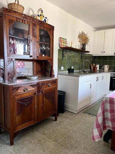 a kitchen with a large wooden cabinet and a sink at Casa rústica com terraço e jardim in Águas