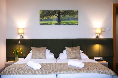 a bedroom with a large bed with two white pillows at Szalajka Liget Hotel és Apartmanházak in Szilvásvárad