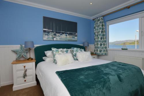 a bedroom with a bed with blue walls and a window at Craignethan in Kames