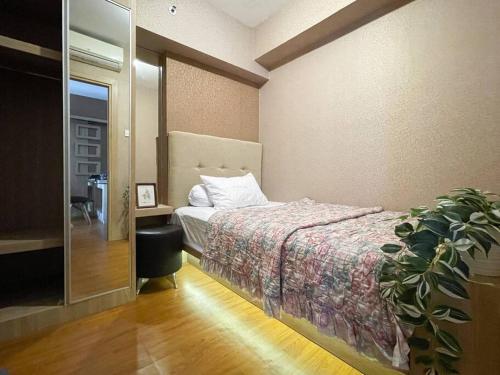 1 dormitorio con 1 cama y una maceta en Modern 2BR Educity Apartment, Pakuwon City, en Surabaya