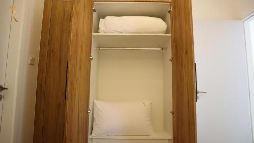 a closet with a bed and a pillow in it at Lavish 2BR Duplex in Masdar City - Luxe Retreat Near Masdar Park & City Centre in Abu Dhabi