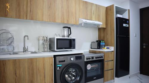 a kitchen with a washing machine and a sink at Bright 2BR Retreat - Sleek Modern Living in Abu Dhabi