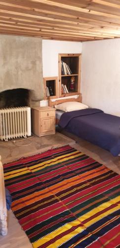 a bedroom with a bed and a rug on the floor at Кюпова къща in Kovačevica