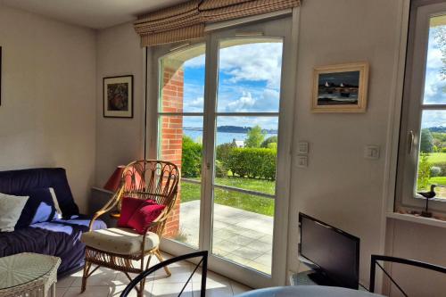 un salon avec vue sur un patio dans l'établissement Nest with beautiful garden and sea view, à Dinard