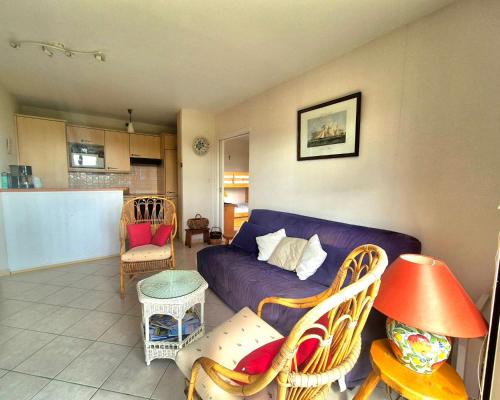 - un salon avec un canapé et des fauteuils violets dans l'établissement Nest with beautiful garden and sea view, à Dinard