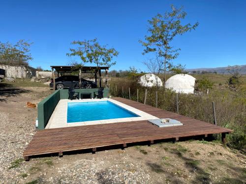 una pequeña piscina con terraza de madera junto a la filosofía en Villa Nicolasa en Villa Yacanto