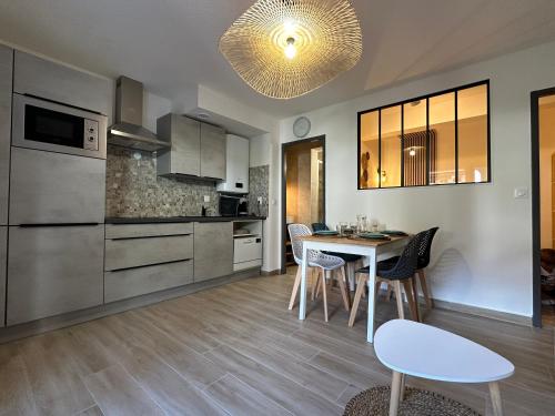 une cuisine et une salle à manger avec une table et des chaises dans l'établissement Appartement climatisé avec chambre et Parking privatif Locations VLD Camargue, à Saintes-Maries-de-la-Mer